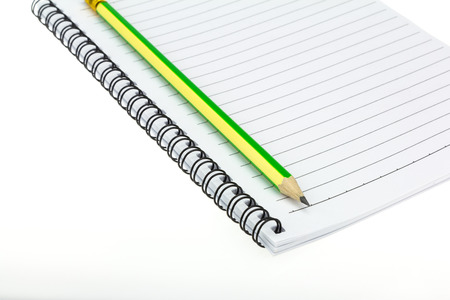 Pencil put on Paper note book  on white backgroundの写真素材