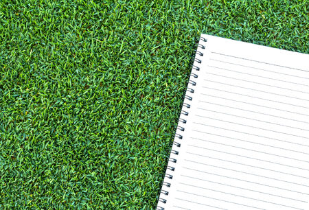 Paper note book  put on Grass backgroundの写真素材
