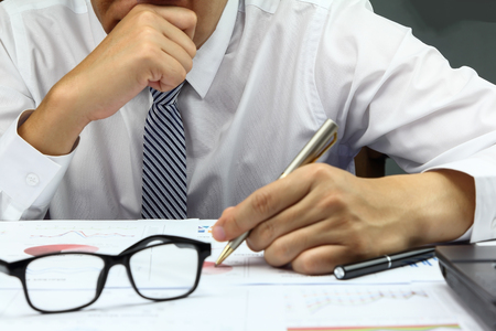 Businessman doing market plan finance with calculate about cost and worry at table office office.の写真素材