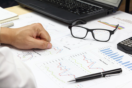 Businessman Summary report and financial analyzing capital Market plan, pen and calculator on paperwork.の写真素材