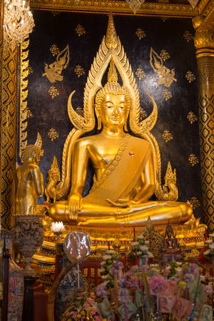 big thai golden Buddha statue decorated with black background and golden cloth chiang rai thailandのeditorial素材