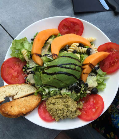 Big breakfast ,toasted bread served with pasta, papaya, tomato, avocado, and fresh salad.の写真素材