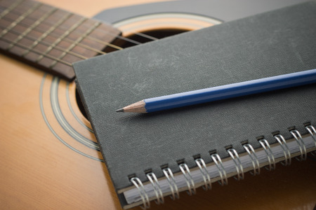 Notebook and pencil on guitar,Writing musicの写真素材