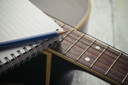 Notebook and pencil on guitar,Writing musicの写真素材