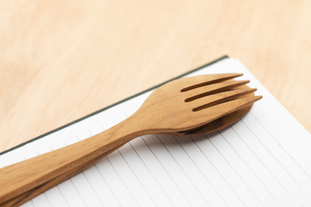 Empty paper for recipe with wooden cooking utensils on kitchen tableの写真素材