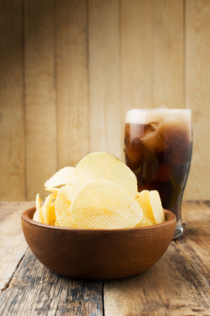 Potato chips and Cola on wood tableの写真素材