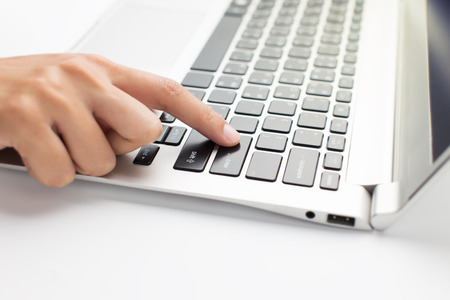 Woman hand press on laptop close up