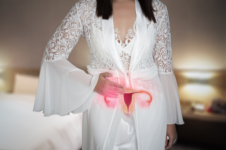 Woman in white silk nightgown and lace robe with uterus pain at night. People having belly ache. illustration of uterus is on the female bodyの写真素材
