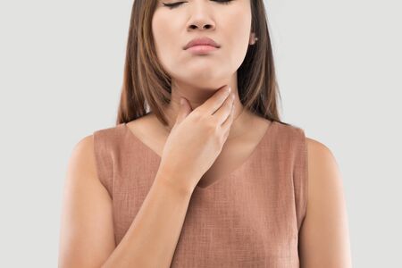 Asian women have symptoms of burning sensation on a gray background, Female with suffering from acid reflux or heartburnの写真素材