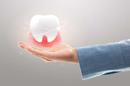 Dentist hands showing white teeth isolated on a light gray background. Tooth and Gum care and...