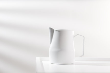 White pitcher on white wooden table in minimalist style.の写真素材