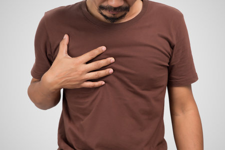 Asian man suffering from gastritis on gray background.の写真素材