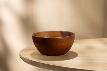 Empty Japanese style wooden bowl placed on a light round table with soft natural light. Minimal composition with clean background, ideal for food mockup or product display.の写真素材