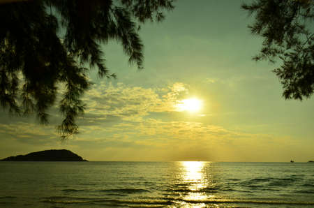 Beautiful sunset above the sea.Gold Sunset, sea and clouds. Beautiful golden orange sunset over the ocean. The sun sets turning the sky yellow, orange & red tones & reflects in the ocean.の写真素材