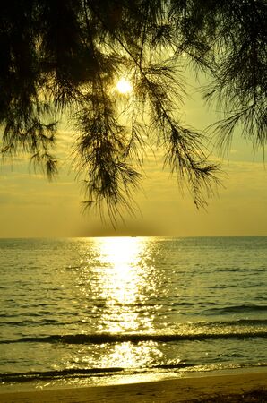 Beautiful sunset above the sea.Gold Sunset, sea and clouds. Beautiful golden orange sunset over the ocean. The sun sets turning the sky yellow, orange & red tones & reflects in the ocean.の写真素材