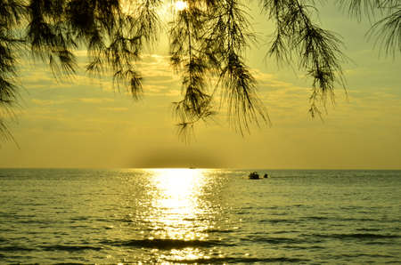 Beautiful sunset above the sea.Gold Sunset, sea and clouds. Beautiful golden orange sunset over the ocean. The sun sets turning the sky yellow, orange & red tones & reflects in the ocean.の写真素材
