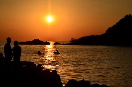 Beautiful sunset above the sea.Gold Sunset, sea and clouds. Beautiful golden orange sunset over the ocean. The sun sets turning the sky yellow, orange & red tones & reflects in the ocean.の写真素材