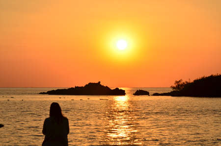 Beautiful sunset above the sea.Gold Sunset, sea and clouds. Beautiful golden orange sunset over the ocean. The sun sets turning the sky yellow, orange & red tones & reflects in the ocean.の写真素材