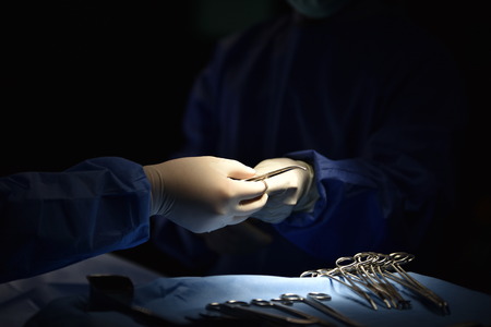 Innovative technology in a modern hospital operating room. Surgical light in the operating room. Preparation for the beginning of surgical operation with a cut. Team surgeon at work in operating room.の写真素材