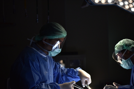Surgical light in the operating room. Preparation for the beginning of surgical operation with a cut. Team surgeon at work in operating room.の写真素材