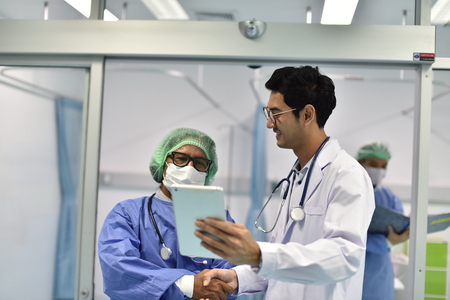 Doctor speaking with his colleague at front i.c.u room Medical theme: doctors are studying a medical report.の写真素材