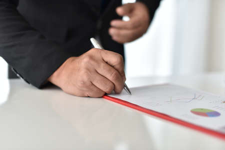 Team Meeting Brainstorming Planning Analysing Concept. Business man hand pointing to graph information in the office Collaboration and business exchanges, brain power, heart, dedicated team managementhe last jigsaw puzzle piece. Finally finding solution.の写真素材