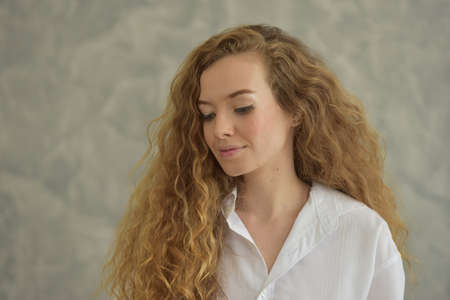 Beautiful woman with a sweet smile. In a lovely posture on a relaxing day.の写真素材