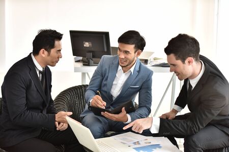Young businessman Success Stories Show the joy with your hands up. In front of his team of colleagues.の写真素材