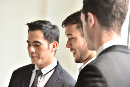 Young men in suits looking delightedの写真素材