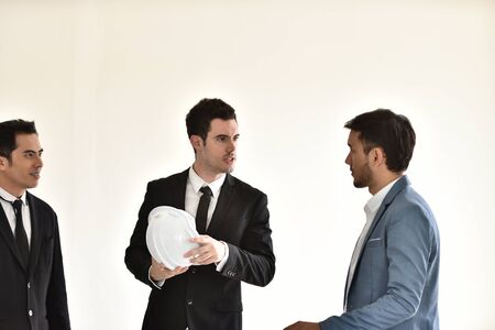 Young engineers and businessmen Talk to a good meeting. Smile to each other.Young businessman Success Stories Show the joy with your hands up. In front of his team of colleagues.の写真素材