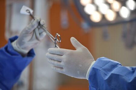 Team surgeon at work in operating room. Surgical light in the operating room. Preparation for the beginning of surgical operation with a cut. The surgeon is performing surgery on the patient.の写真素材