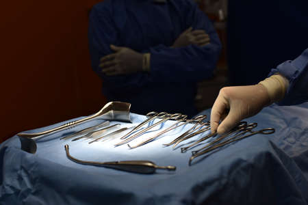 Team surgeon at work in operating room. Surgical light in the operating room. Preparation for the beginning of surgical operation with a cut. The surgeon is performing surgery on the patient.の写真素材