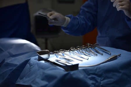 Team surgeon at work in operating room. Surgical light in the operating room. Preparation for the beginning of surgical operation with a cut. The surgeon is performing surgery on the patient.の写真素材