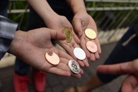 Hands Holding Golden and Silver Bitcoin Virtual Money Cryptocurrency. Bitcoin in the hands of a boy holds a metal coin of crypto currency in his handsの写真素材