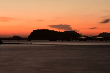 Twiligth time. After sunset Red orange sky and golden cloud.Beautiful sunset above the sea.Gold Sunset, sea and clouds. Beautiful golden orange sunset over the ocean. The sun sets turning the sky yellow,の写真素材