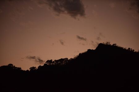 After sunset The sky before the evening with golden clouds, orange, beautiful shape resembles gotzila.の写真素材