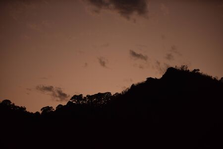 After sunset The sky before the evening with golden clouds, orange, beautiful shape resembles gotzila.の写真素材