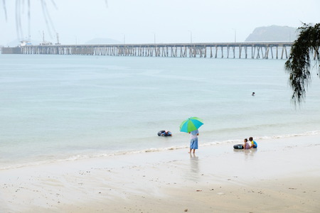 The tourists are swimming at the beach. And stroll along the sandy beach. Must use the umbrella on a rainy day with a rain storm at the beach, Sattahip, Chonburi, Thailand on April 28, 2018.のeditorial素材