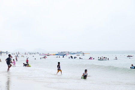 The tourists are swimming at the beach. And stroll along the sandy beach. Must use the umbrella on a rainy day at the beach, Sattahip, Chonburi, Thailand on April 28, 2018.のeditorial素材