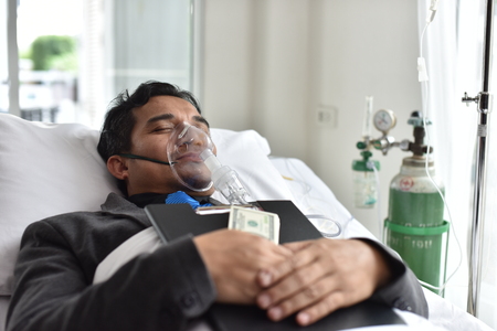 Businessmen are also working and making money while they sleep in bed in the hospital. Business Conceptsの写真素材