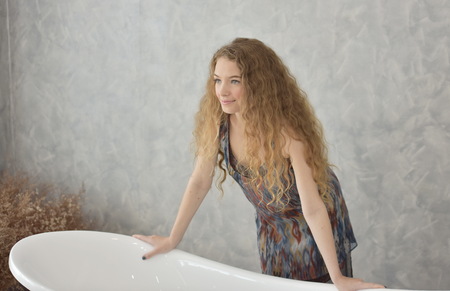 Portrait of young woman laying in bathtub.relaxed time in bathroom.young woman relaxing in bathtub.Beautiful woman with a sweet smile. In a lovely posture on a relaxing dayの写真素材