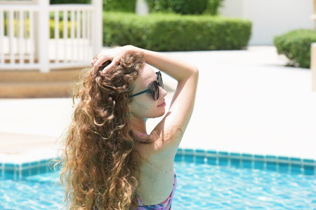 Beautiful girl in a beautiful swimsuit on a bright day at the pool. Portrait of beautiful elegant...