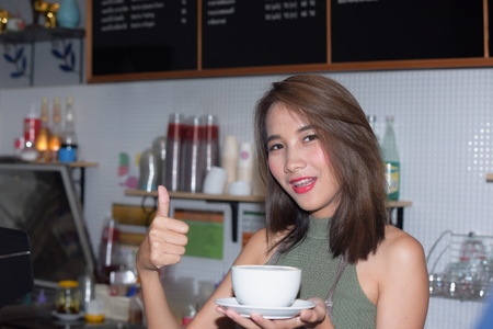 Beautiful women look smart and smart in a bright posture. Have a background image as a kitchen.
