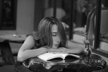 Portrait of a beautiful young woman reading a book Relaxing and comfortable.の写真素材