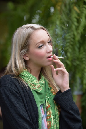 Portrait of a beautiful young woman smoking cigarettes Health Hazards.の写真素材