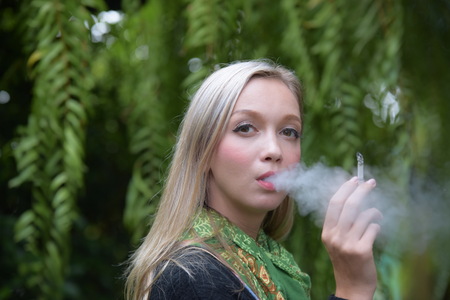 Portrait of a beautiful young woman smoking cigarettes Health Hazards.の写真素材