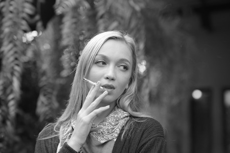 Portrait of a beautiful young woman smoking cigarettes.Health Hazards.の写真素材
