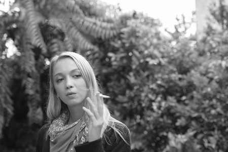 Portrait of a beautiful young woman smoking cigarettes.Health Hazards.の写真素材