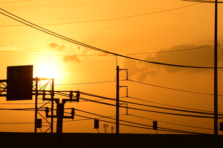 Sunset.High-power transmission towers with beautiful skies are golden in the pre-dark days.の写真素材