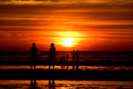 Sunset at the beautiful beach view Among the many people come to play in the sea before the dusk.silhouette of sunset at beach.の写真素材
